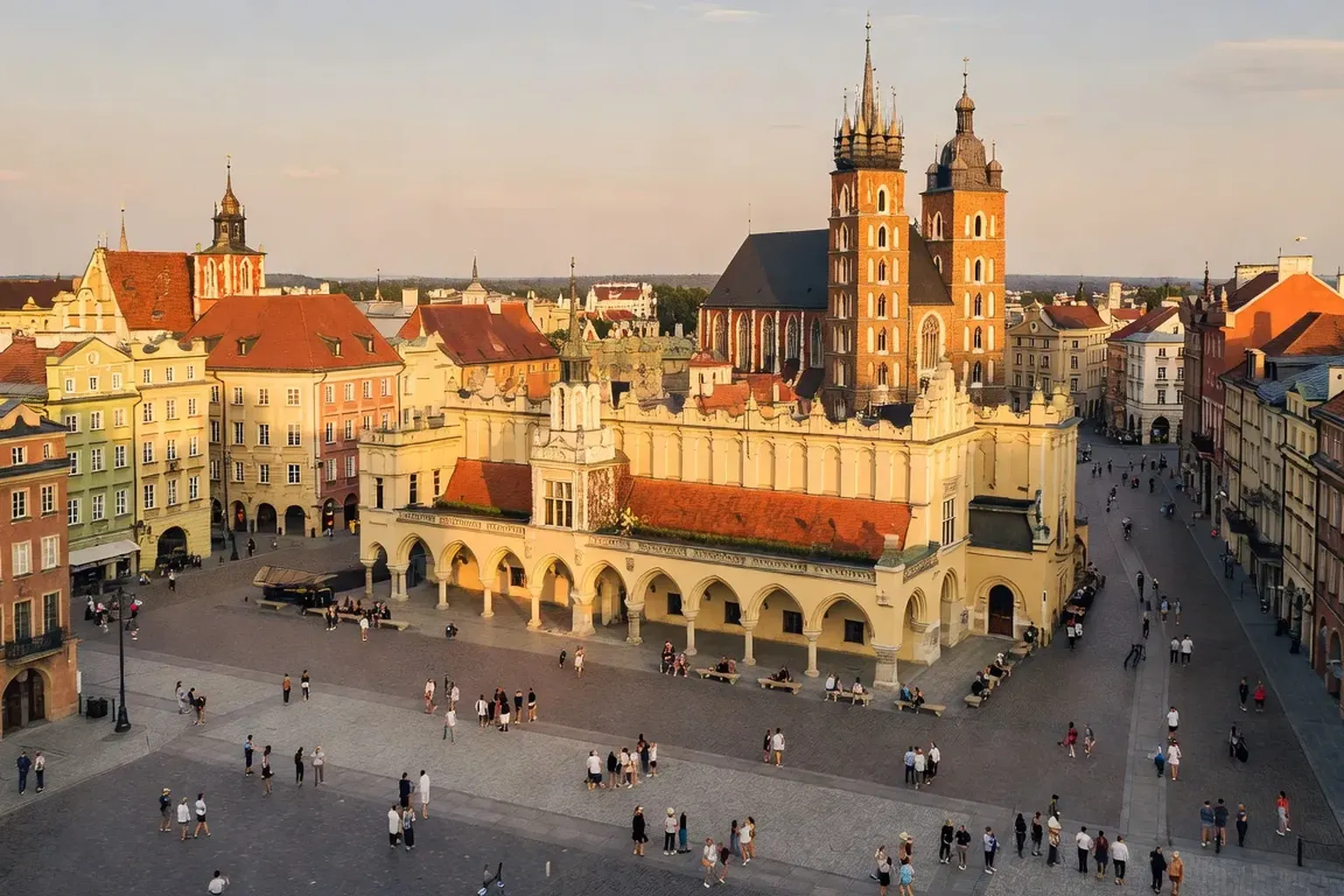 Place du Marché de Cracovie (Rynek Główny) en été, Halle aux draps Sukiennice et basilique Sainte-Marie, touristes animés